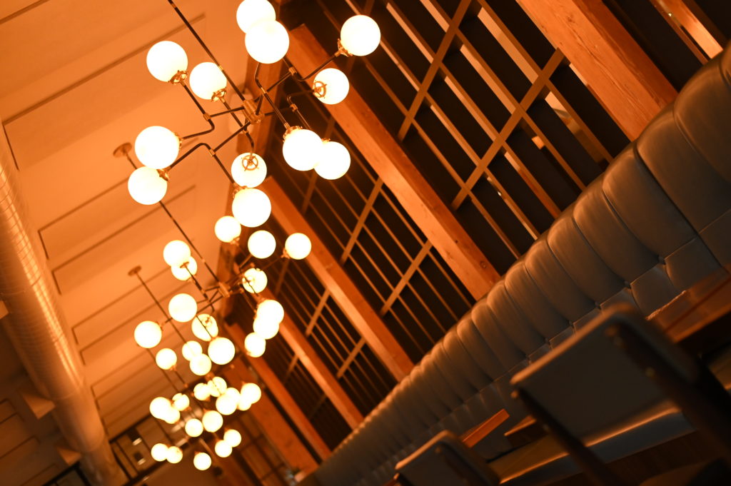 Modern light fixtures hanging above empty restaurant seating
