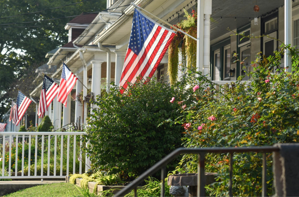 American Flags hang on porches on houses in Lititz, Pennsylvania