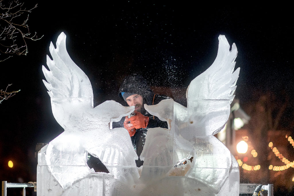 Ice Carver carving lovebirds and heart sculpture out of ice during Lititz's Fire and Ice Festival